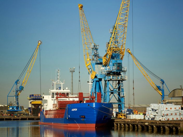 A ship unloading cargo with cranes at an East coast port in United Kingdom.