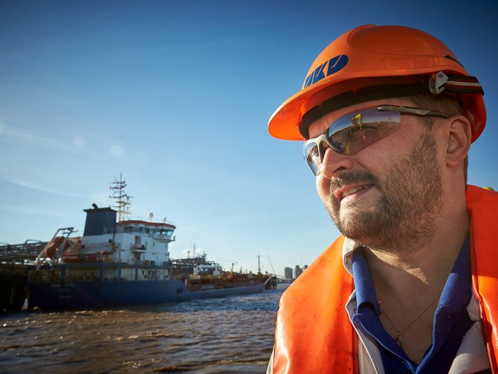 News photography of a worker looking out to sea on a workboat in the Humber, Lincolnshire.