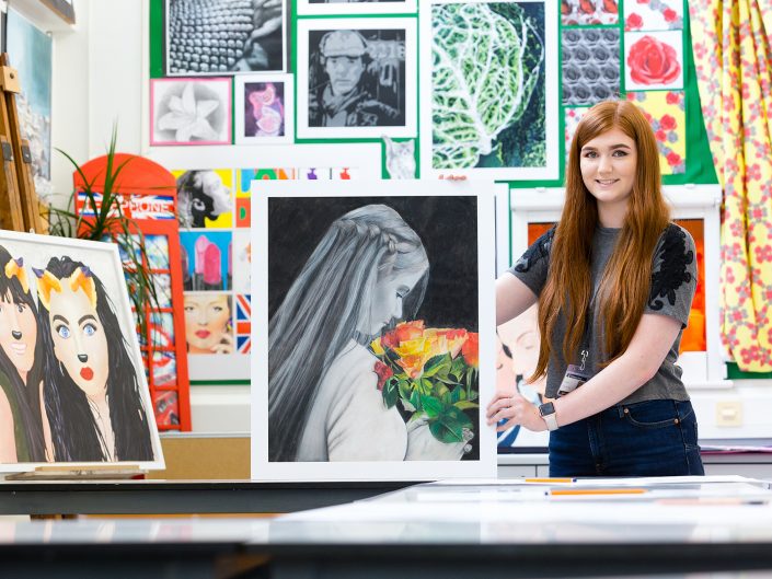 A female college Student displaying her artwork for a press photo in Hull, East Yorkshire.