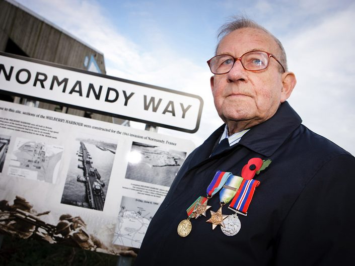 News photograph of a war veteran with the Normandy Way road signage in Goole, East Yorkshire.