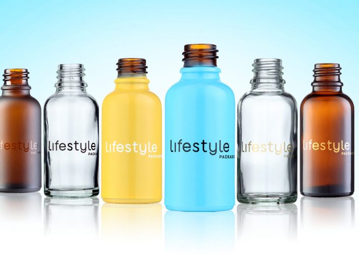 Multi-coloured glass bottles on a light blue backgroung. Photographed in a Hull, Product photography studio.