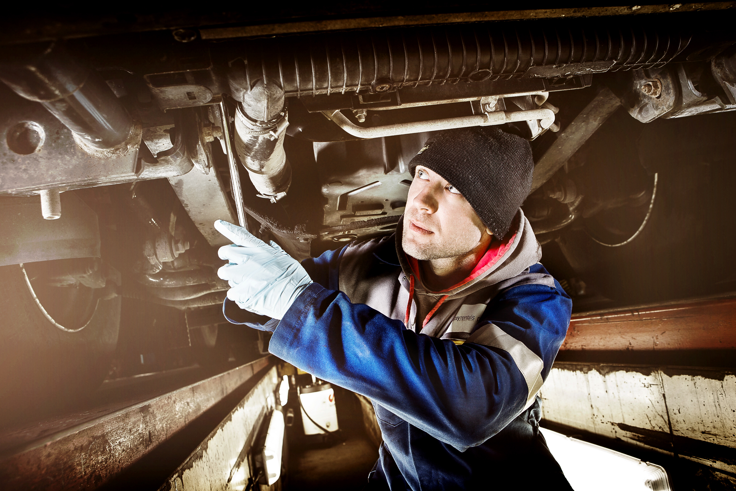 Mechanic working on a truck within an industrial environment.
